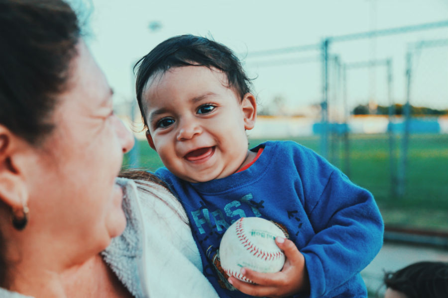 An American boy citizen holding a baseball and smiling