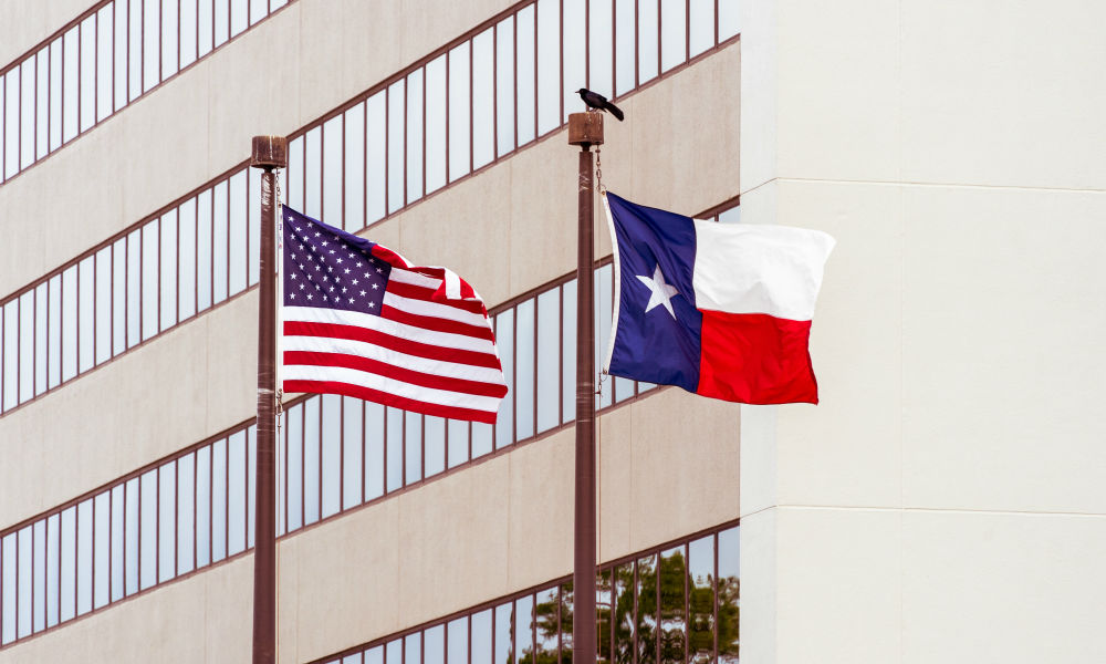 Texas flag and American flag in front of law firm building