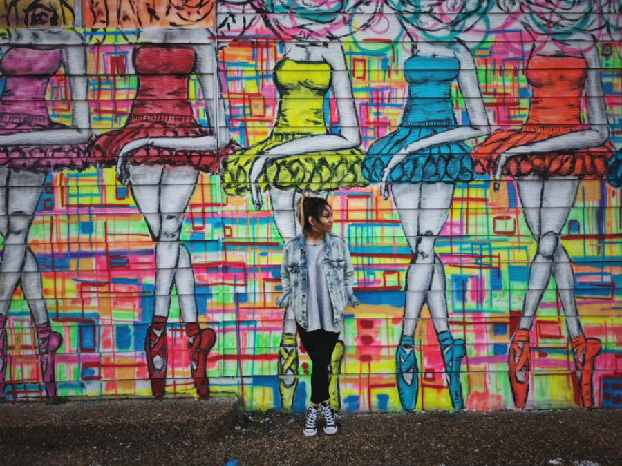 Girl stands in front of a bright graffiti wall in Houston, Texas
